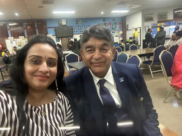 Rakesh Raizada with a smiling community member at a community hall