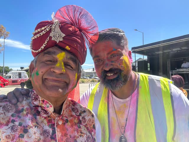 Rakesh Raizada and a friend covered in Holi colours