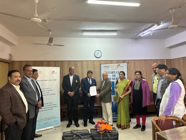 Rakesh Raizada accepting a certificate from Rotary partners during a handover of jumpers knitted for newborn babies