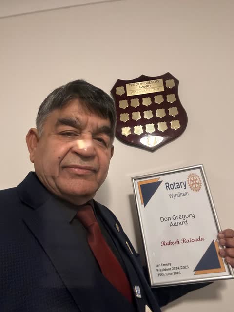 Rakesh Raizada holding his Rotary Wyndham Don Gregory Award certificate beside the award shield
