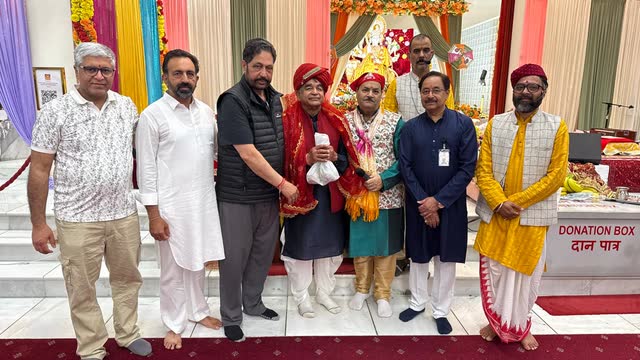 Rakesh Raizada, wearing a red shawl, with community leaders at a temple celebration