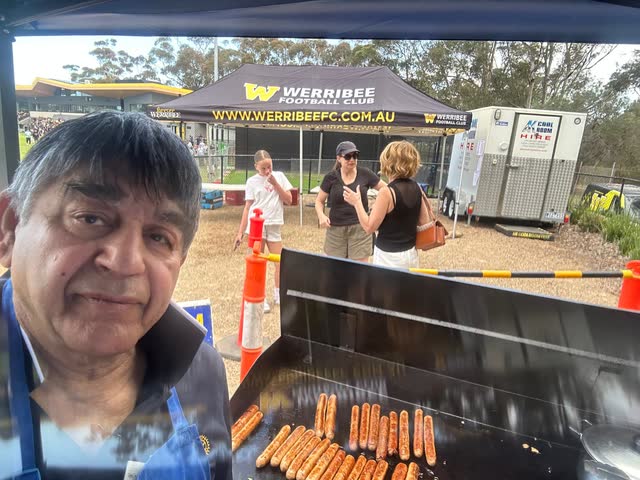Selfie of Rakesh Raizada cooking sausages on the barbecue at Werribee Football Club